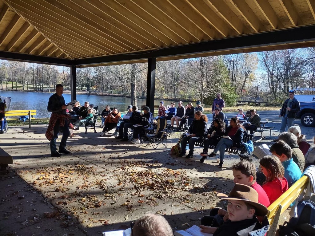 Outdoor worship and singing by the lake